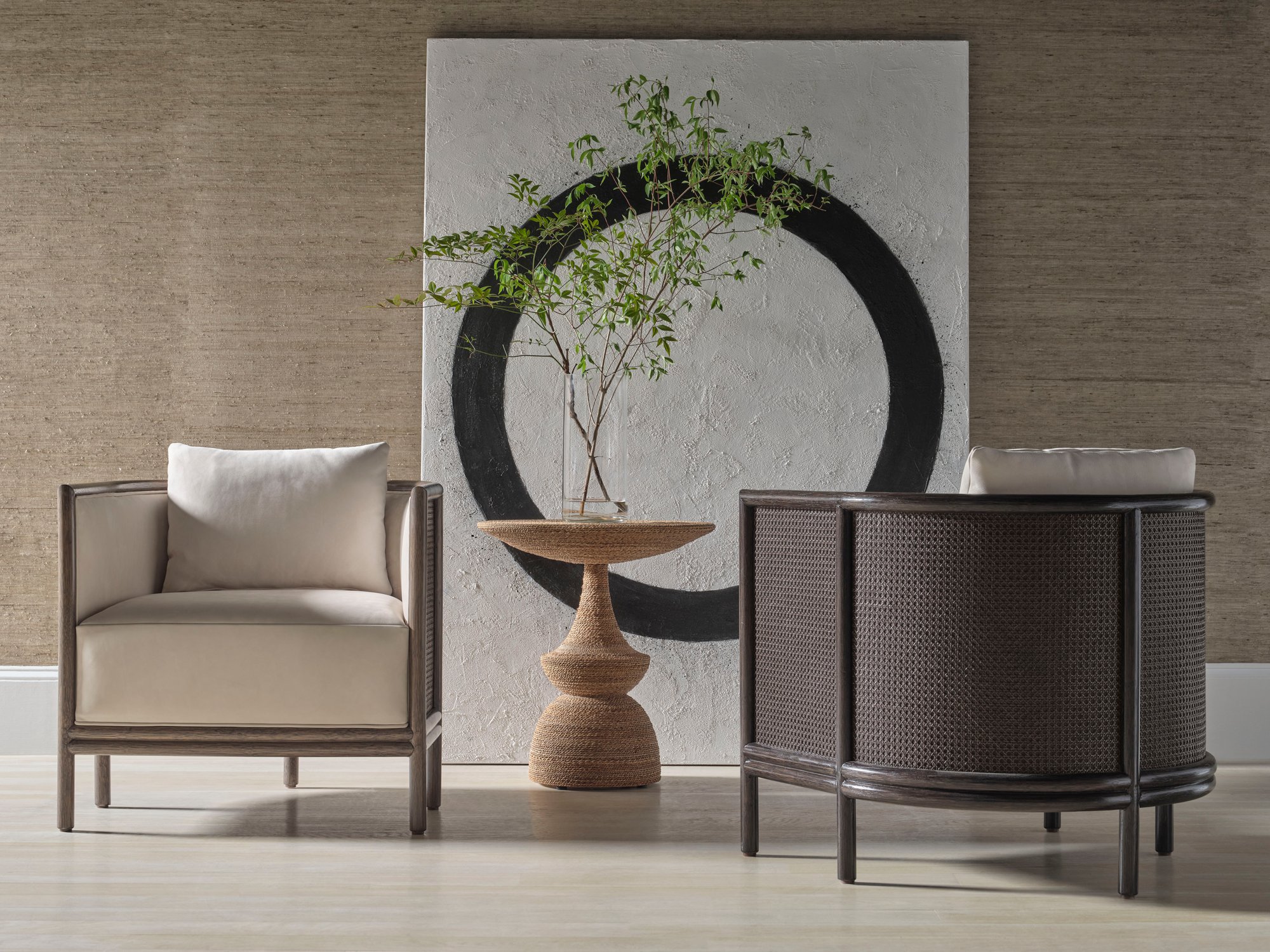Pair of McGuire woven armchairs beside a sculptural pedestal table