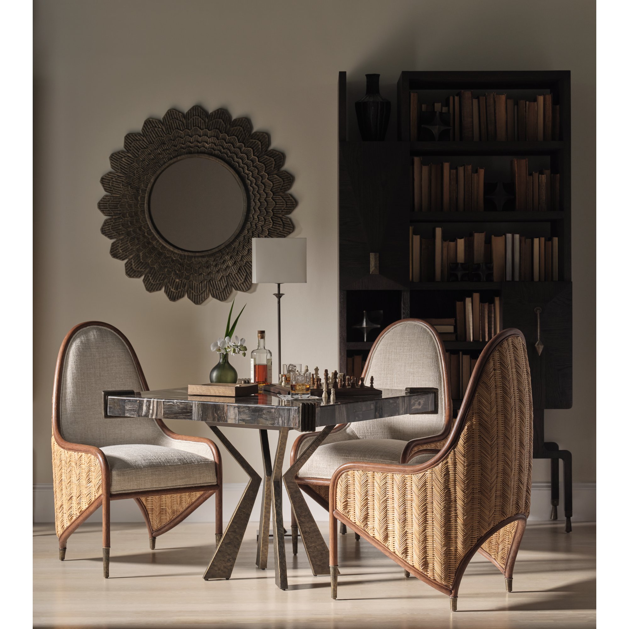 McGuire woven cane game chairs around a polished table with sunburst mirror